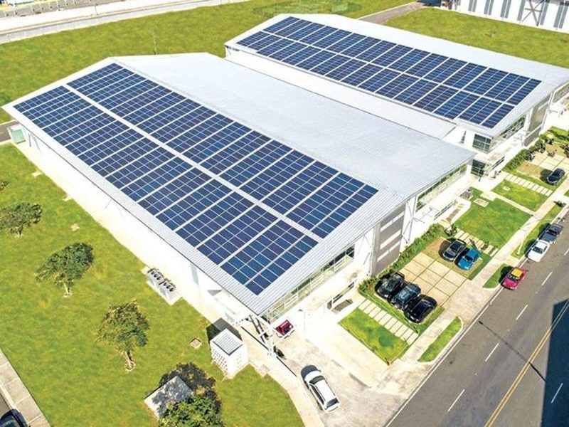 Rooftop solar array with inverter installed on a building at sunset