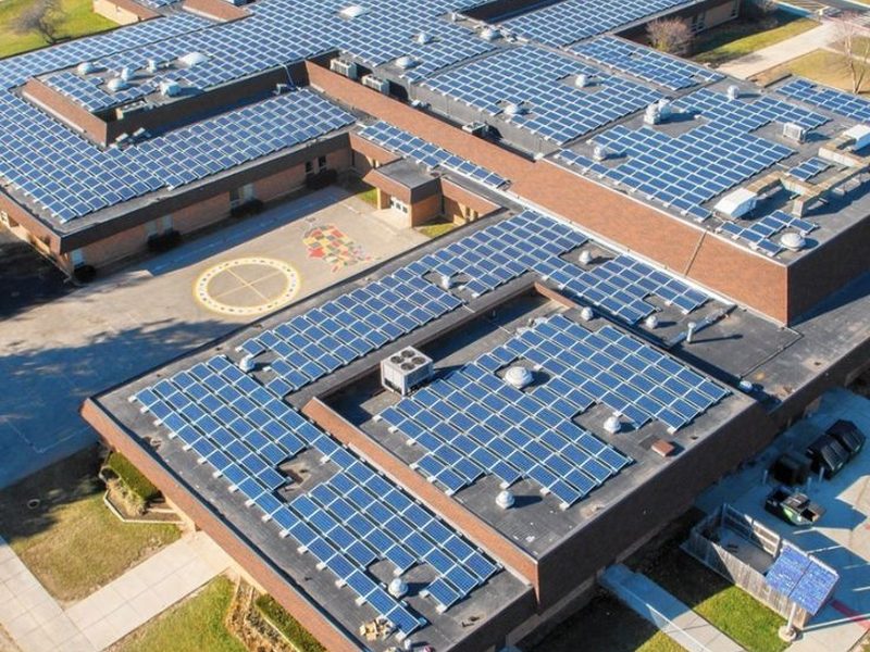 Aerial view of a school campus with solar panels covering every rooftop