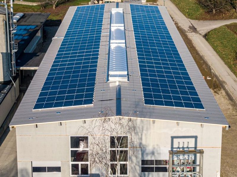 Aerial view of a large rooftop solar array on an industrial warehouse